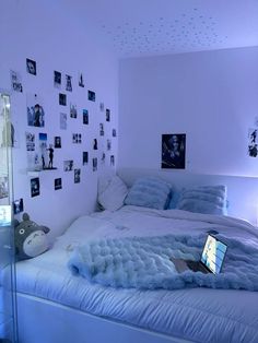 a laptop computer sitting on top of a bed in a room with pictures on the wall