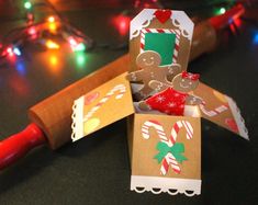 an origami gingerbread man with candy canes and lights in the background