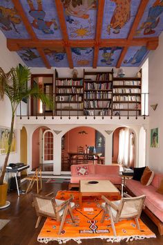 a living room filled with furniture and a painting on the ceiling above it's bookshelf