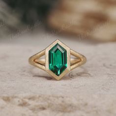 an emerald colored stone in a gold ring