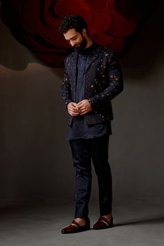 Midnight Rose Short Jacket| Jatin Malik Introducing our exquisite midnight rose short jacket, featuring a sophisticated double lapel detail. This stunning piece is hand-embroidered using the traditional zardozi technique with midnight and wine threads, creating a rich and luxurious texture. Paired with a short-length tone-on-tone kurta and tapered trousers, this ensemble perfectly balances elegance and contemporary style. Ideal for any special occasion, this outfit is a testament to impeccable craftsmanship and refined design. Included in purchase: Short Jacket, Kurta, Trousers Product Specification Color: Midnight Blue Fabric: Linen Silk Occasion: Engagement, Wedding, Bridal, Reception Style: Short Jacket, Kurta, Trousers Care: Dry Clean Work: Hand Embroidery Customization options:Can be Elegant Formal Outerwear With Chikankari Embroidery, Designer Nehru Jacket With Chikankari Embroidery For Party, Elegant Bandhgala With Floral Embroidery For Reception, Elegant Fall Outerwear With Zari Work, Traditional Embroidered Blazer For Reception, Elegant Nehru Jacket With Floral Embroidery For Reception, Festive Bandhgala With Floral Embroidery For Party, Elegant Festive Bandhgala With Floral Embroidery, Festive Party Bandhgala With Floral Embroidery