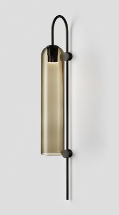 a wall light that is on the side of a white wall with a black handle