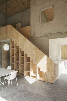 a table and chairs in a room with wooden shelves on the wall next to it