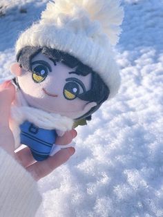 someone is holding a doll in the snow