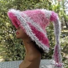 Add this gorgeous one of a kind fuzzy pink witch hat to your accessories for your next festival, holiday party or cosplay event.  You'll be the envy of all your witchy friends when you walk into a room.  Beautifully crafted in a double thickness with a soft texture that you will fall in love with.  Brim can be left down or rolled up. Created with gray acrylic yarn and a variety of pink eyelash yarn. Hand wash gently with a mild detergent and lay flat to dry. 25" from brim to tip before fringe (f Pink Wide Brim Costume Hat For Festival, Pink Adjustable Mini Hat For Costume Party, Whimsical Pink Costume Hats And Headpieces For Carnival, Pink Whimsical Costume Hats For Carnival, Whimsical Pink Costume Hats For Carnival, Pink Halloween Costume Hat, Adjustable Pink Halloween Costume Hats And Headpieces, Adjustable Pink Halloween Costume Hat, Adjustable Pink Costume Hat For Halloween