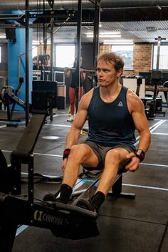 a man sitting on top of a bench in a gym