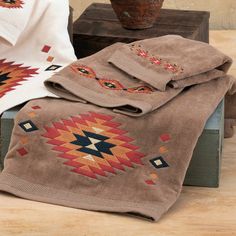 two blankets are sitting next to each other on a wooden table with a potted plant in the background