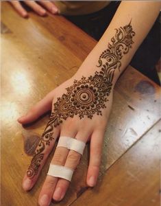 a woman's hand with henna tattoos on it