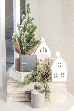 a small christmas tree sitting on top of a stack of books next to a mug