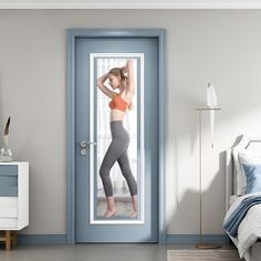 a woman standing in front of a door with her hand on her head and wearing leggings