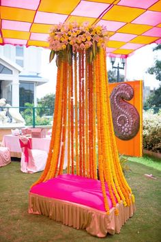 an outdoor wedding setup with pink and yellow drapes