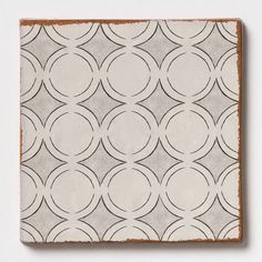 a square tile with circles on it in grey and white colors, against a white background