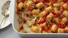 a casserole dish with meat and vegetables in it next to a spoon on a table