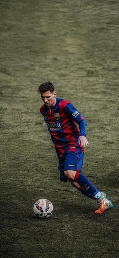 a man kicking a soccer ball on top of a field