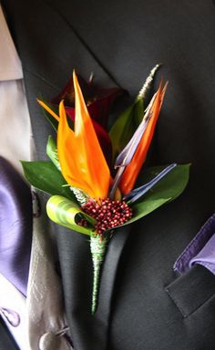 a boutonniere with orange and red flowers on it's lapel