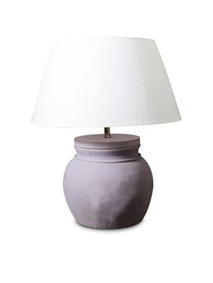 a white lamp sitting on top of a table next to a gray vase with a white shade