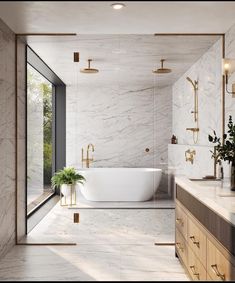 a bathroom with marble walls and flooring, gold fixtures and a large bathtub