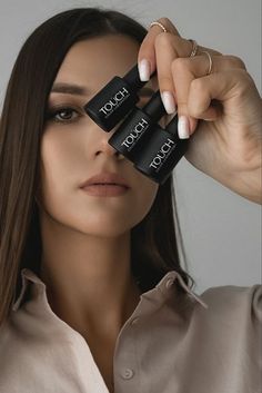 a woman holding two black lipstick sticks in front of her face with the words touch touch written on them