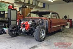 an old car is parked in a garage with its hood up and the engine exposed