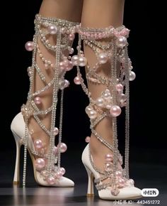 a pair of high heeled shoes with pearls and chains