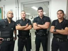 four police officers standing in front of a mirror with their arms crossed and looking at the camera