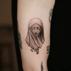 a woman's arm with a tattoo on it that has an image of a nun