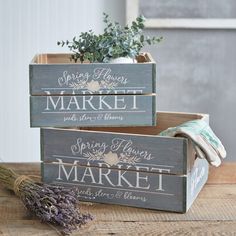 two wooden boxes with herbs in them sitting on a table next to a lavender plant