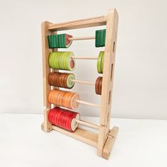 a wooden toy with spools of thread in it