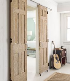 an open door leading to a bedroom with a guitar on the floor next to it