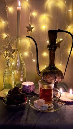 tea and candles on a table with lights in the background