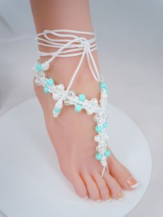 Very cute barefoot sandals that are available in two colors of either turquoise or purple.  Sandals have turquoise, purple, white or clear plastic pony beads that are woven with a white cording.  Cording will wrap around the ankle two to three times depending on the size of your angle.  Once the cord is wrapped around the ankle tie a bow and pull tight to secure the bow.  There are pony beads on the ends that dangle down. Photo #5 shows how they would look with a pair of thong style sandal shoes Handmade White Barefoot Sandals For Beach, Handmade Adjustable Toe Ring Sandals With Ankle Strap, White Bohemian Barefoot Sandals With Ankle Wrap, White Handmade Bohemian Barefoot Sandals, Handmade White Bohemian Barefoot Sandals, White Bohemian Handmade Barefoot Sandals, White Bohemian Toe Ring Barefoot Sandals, White Bohemian Barefoot Toe Ring Sandals, Adjustable Toe Ring Barefoot Sandals For Summer