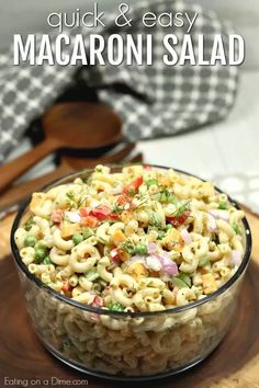 macaroni salad in a glass bowl on top of a wooden cutting board with text overlay