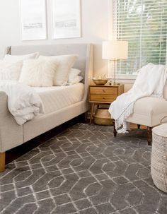 a white bed sitting in a bedroom next to a window