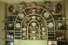 a shelf filled with lots of different types of plates and bowls on top of it