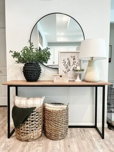 a table with two baskets and a mirror on it