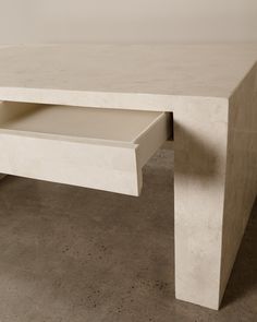 a white table sitting on top of a cement floor