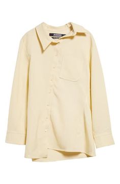 The asymmetric placket of this butter-yellow shirt shifts the collar, J-shaped chest pocket, hem and drape of the back box pleat slightly off-kilter. Asymmetric front-button closure Asymmetric point collar Long sleeves with one-button cuffs Chest patch pocket 88% viscose, 12% polyester Dry clean Imported Designer Clothing Yellow Workwear Tops With Button Cuffs, Yellow Tops With Button Cuffs For Work, Yellow Button-up Blouse For Work, Yellow Collared Shirt For Work, Collared Yellow Shirt For Work, Elegant Yellow Workwear Shirt, Elegant Yellow Collared Shirt, Elegant Yellow Collared Blouse, Chic Yellow Button-up Shirt