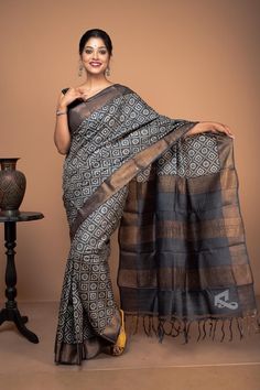 Black and gold are always a gorgeous combination for your glamorous evening wear. This Jafri-inspired hand-block printing zari border tussar black saree is just perfect for any occasion. Though it is hand-block printed work, it looks like a hand-woven print. The blouse piece and aanchal are plain to complement the busy block print. This black saree is silk mark certified. Hence, you don't have to worry about the quality of the product. You always get the best quality saree from us. This amazingly soothing block-printed zari border tussar saree is the epitome of gorgeousness in every possible way. An ideal party wear Nothing beats the beauty quotient that a tussar silk saree offers. You can wear this saree as party wear. This black saree party wear gives you a royal appearance. This saree h Black Saree With Blouse, Saree For Party Wear, Saree For Party, Block Print Saree, Royal Look, Black Saree, Party Kleidung, Tussar Silk Saree, Saree Look