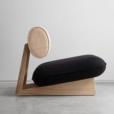 a black cushion sitting on top of a wooden stand