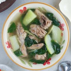 a bowl filled with meat and vegetables on top of a table