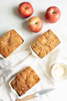 three pieces of apple pie sitting on top of a table next to some apples and butter