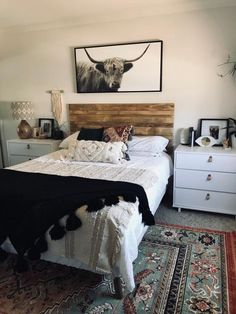 a room with a bed, rugs and pictures on the wall above it is shown