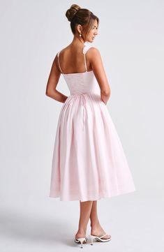 a woman in a pink dress is looking back