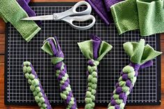 some purple and green items sitting on a table next to scissors, napkins, and towels