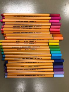 several colored pencils are lined up on a table with the same color as each other