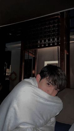 a young boy wrapped in a white blanket