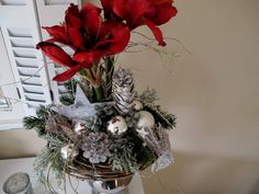 a basket filled with red flowers sitting on top of a table next to a window