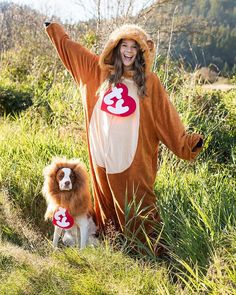 a woman in a dog costume standing next to a small dog