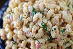 macaroni salad in a blue bowl with parsley on top