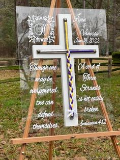 a wooden easel with a cross on it and the names of two different people